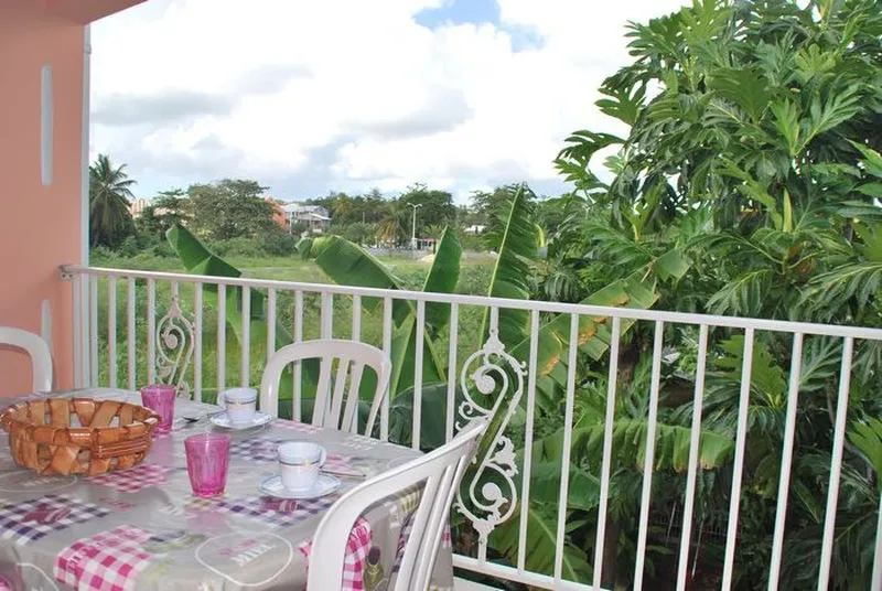 La terrasse du studio Carambole au premier étage, ouverte sur le jardin de la résidence.