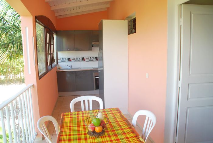 La cuisine extérieure de Carambole installée sur la terrasse avec table à quatre.