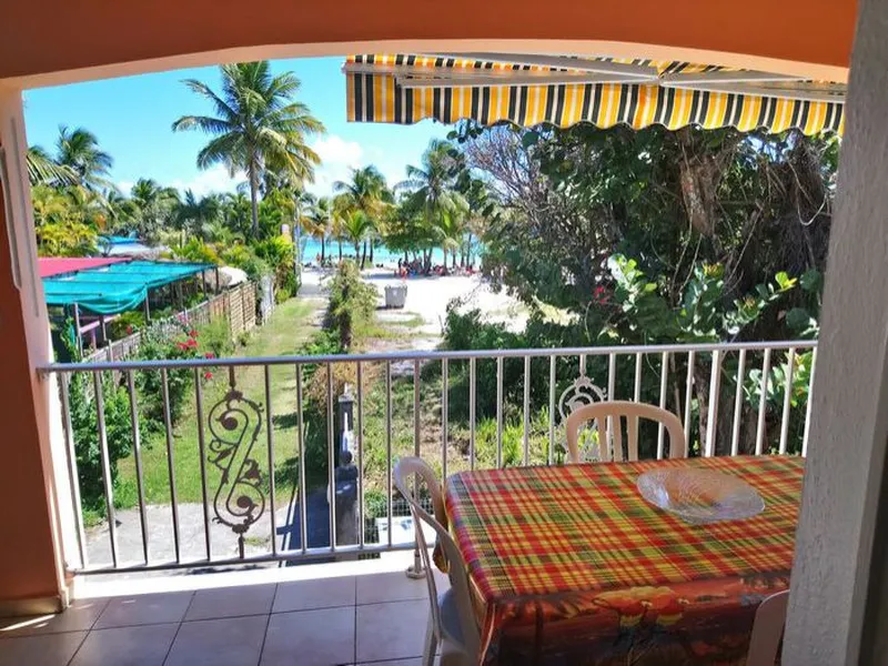 La terrasse ensoleillée de l'appartement Maracudja avec sa cuisine extérieure et la vue sur le lagon.