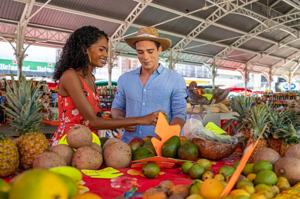 Le marché couvert de Pointe-à-Pitre, animé, avec les étals d'épices et de fruits tropicaux.