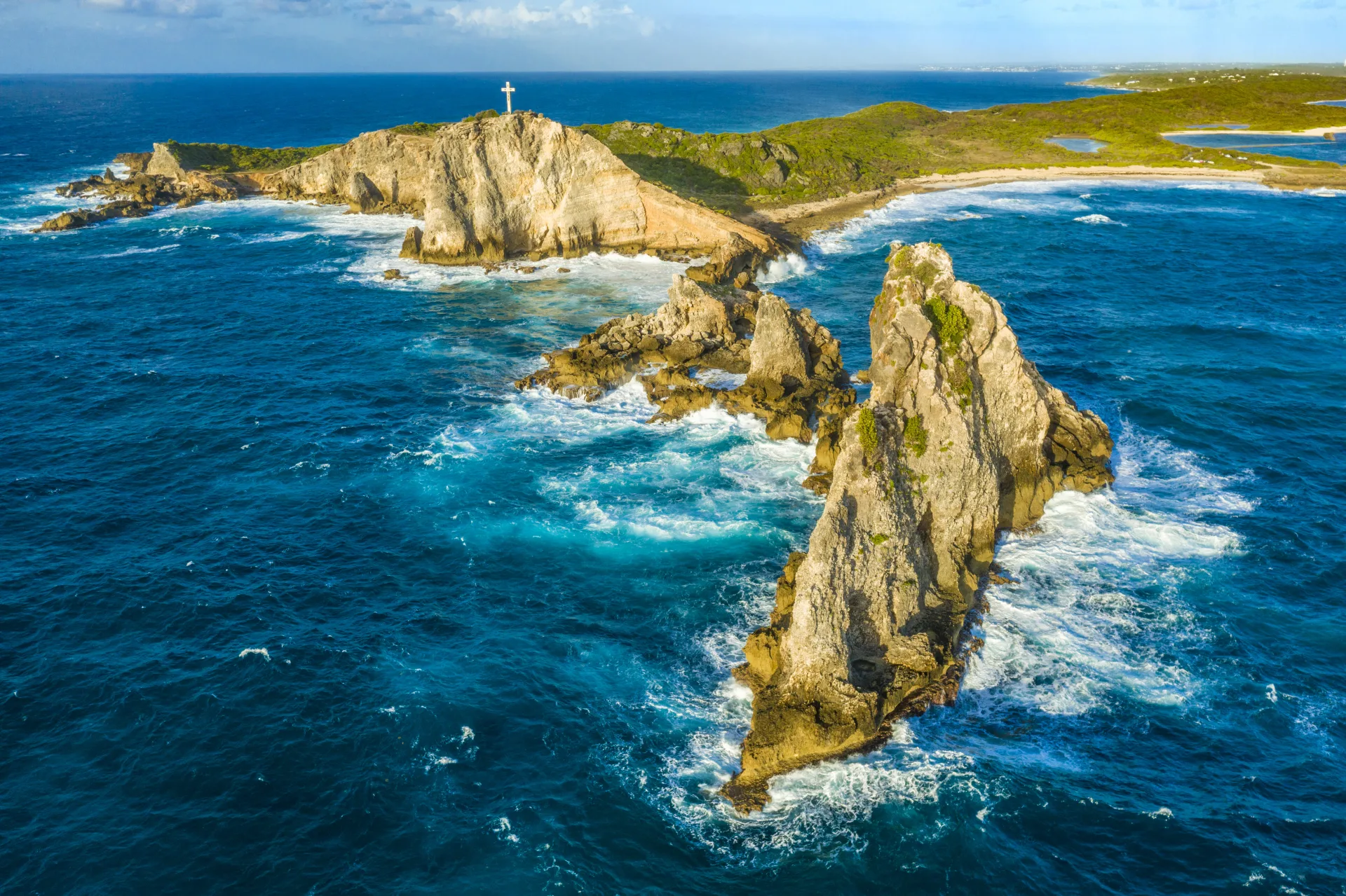 La Pointe des Châteaux : falaises rocheuses et croix panoramique surplombant l'océan.