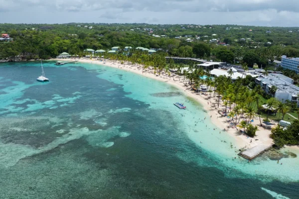 Le lagon de Sainte-Anne vu depuis la plage : eau turquoise peu profonde et baigneurs en famille.